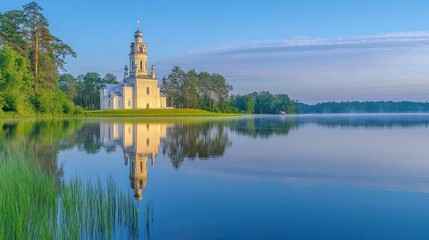 Obraz premium Serene sunrise over lake reflecting white church.