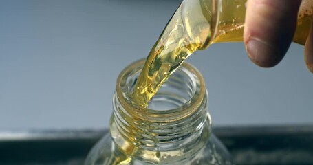 Super slow motion macro of lab worker pours beer into glass ware for quality testing, ensuring it meets production standards. The beer is carefully inspected in brewery with precision and dedication.