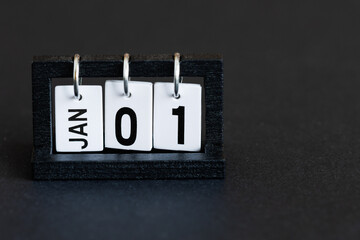 A perpetual desktop calendar on a black background. January 1st. The first day of the new year.