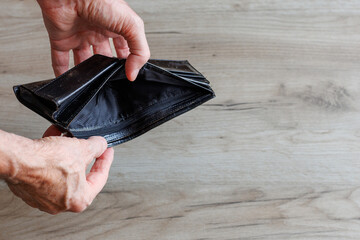 Empty wallet in hands of man. Financial crisis and poverty concept.