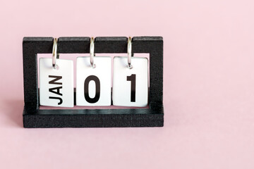 Desktop calendar on a pink background. The first day of the new year. January 1st.