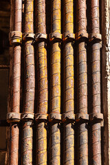 detail of old industrial brick wall with rotten and rusty water and gas tubes as symbol