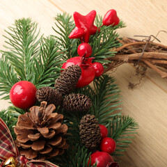 Christmas wreath over wooden background, closeup view. Xmas decoration.