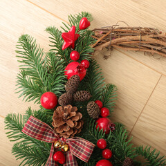 Christmas wreath over wooden background, closeup view. Xmas decoration.