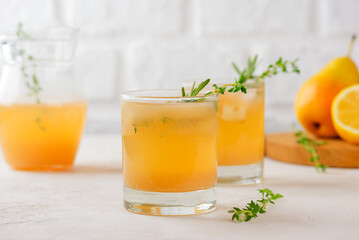 Pear juice, lemonade with ice, fresh fruits, rosemary and thyme on a white table. Healthy drink, sugar.