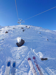 Bright blue skies and snowy slopes in Val Thorens, France. Skiers enjoy fresh powder and the thrill of the mountains beneath a vibrant winter sun.
