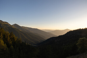 Landscape of the forest covered mountain range at sunset or sunrise