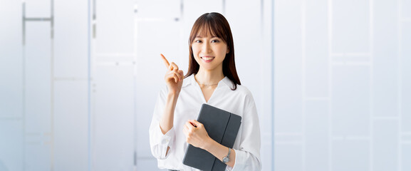 タブレットを持って案内をする笑顔の女性・ビジネスウーマン