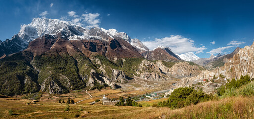 Scenic panoramic view of snow mountains and forests of famous Annapurna range in Himalayas near ancient village of Bhraka, Nepal