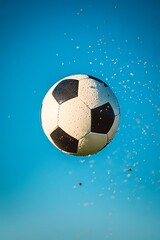 Naklejka premium Soccer Ball Being Kicked in Mid-Air Against Clear Sky 