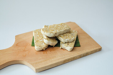 Raw tempeh that has been cut on a cutting board
