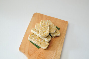 Raw tempeh that has been cut on a cutting board