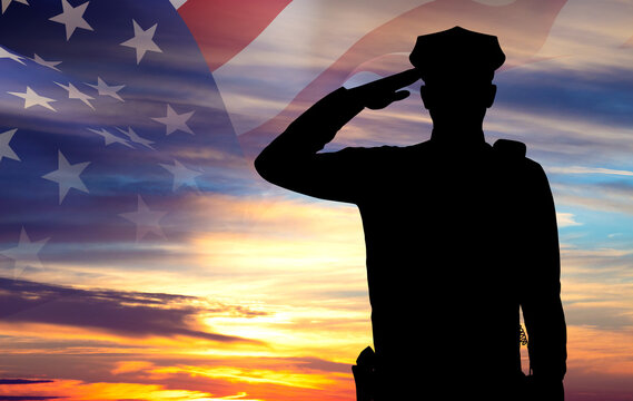 Silhouette of a police officer against the sunset. American flag against the sunset. National Law Enforcement Appreciation Day concept