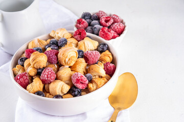 Tiny breakfast croissant cereals with fresh berries and milk