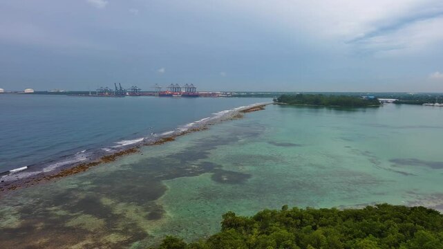 La Matica islet, impenetrable mangrove forest, Playa Boca Chica beach, Caucedo port in background, Dominican Republic. Aerial backward, sky for copy space