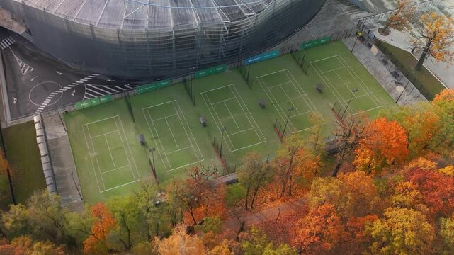 Aerial shot of tennis courts near the Darius and Girenas stadium with colorful trees in Kaunas, Lithuania in the autumn season