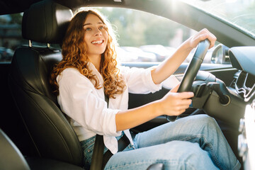 Young woman driving vehicle confidently, seatbelt. Automobile travel.