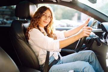 Young woman driving vehicle confidently, seatbelt. Automobile travel.