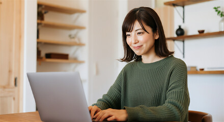 部屋でパソコンを使う女性