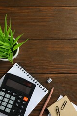 Top above overhead view photo of office accessories calculator, notebook and pen on wooden backdrop with blank empty space
