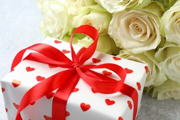 Gift box with white roses on gray background