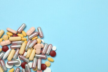 Various tablets and capsules on a colored background
