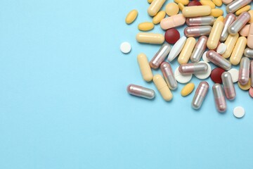 Various tablets and capsules on a colored background