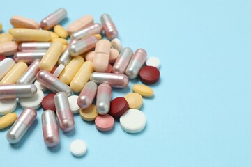 Various tablets and capsules on a colored background