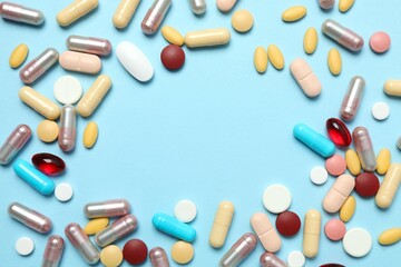 Various tablets and capsules on a colored background
