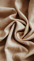 A close-up of soft, beige fabric elegantly draped and twisted, showcasing its texture and subtle sheen.