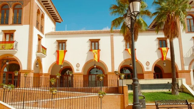Plaza de Espana in Palos de la Frontera, Huelva, Andalucia, Spain, adorned with Spanish flags, radiates national pride and history