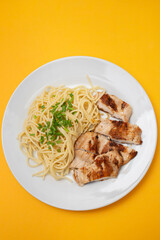 boiled spgaghetti with grilled chicken breast on plate