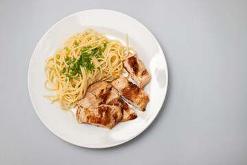 boiled spgaghetti with grilled chicken breast on plate