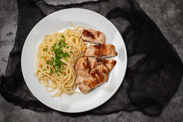 boiled spgaghetti with grilled chicken breast on plate