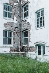 Exploring the remnants of an old sanatorium in a secluded location, revealing its crumbling architecture and overgrown surroundings