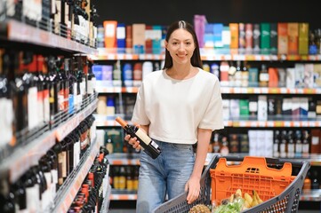girl chooses wine in supermarket