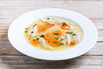 Homemade chicken soup on wooden table