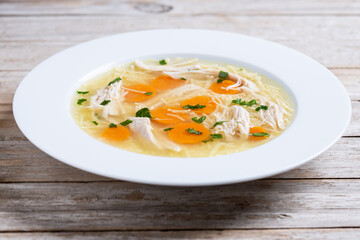 Homemade chicken soup on wooden table