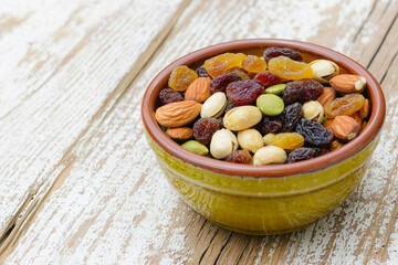 Fototapeta premium Dried fruits and nuts in a rustic bowl on table