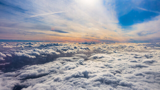 Vista espectacular de un amanecer sobre un mar de nubes, con el sol iluminando el cielo en tonos dorados y azules.