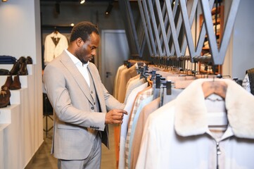 Obraz premium A handsome young african gentleman buying an elegant suit