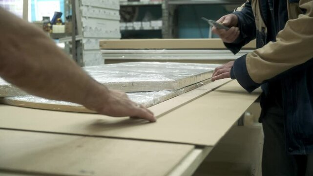 Close-up of furniture packers taking measurements for packing goods. Production and packaging concept.