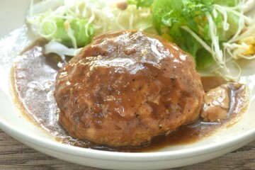 grilled chop pork steak burger dressing gravy sauce with salad on plate