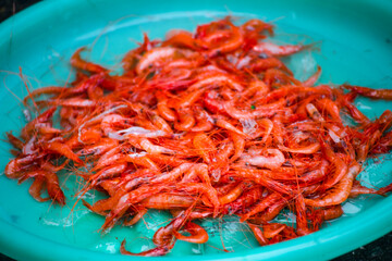 a plate of vibrant red fire shrimp is piled up