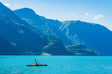 Kayaking amidst stunning fjords in Norway with breathtaking mountain views and clear blue waters
