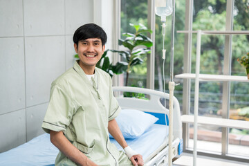 Young Patient in the hospital. Healthcare medical in the hospital. Young asian man wearing patient uniform