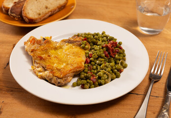 Delicious crispy chicken with peas as a side dish on a plate