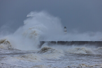 Waves crashing over the sea defence at Seaham, County Durham, England UK.