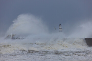 Waves crashing over the sea defence at Seaham, County Durham, England UK.