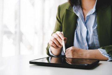Young woman is working online using a digital tablet. Taking notes on a laptop Students use tablets to study online.